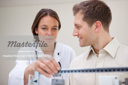 Doctor adjusting scale for her smiling patient