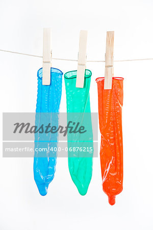Condoms hanging on line on white background