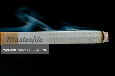 Lit cigarette on black background