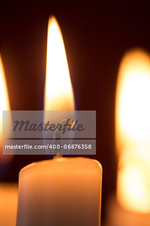 Close up of lit candle on dark background