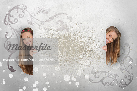 Pretty girls peeking out from behind copy space on grey art deco style background