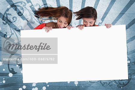 Smiling girls looking down at white copy space screen on blue art deco style background