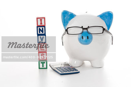 Blue and white piggy bank wearing glasses with invest building blocks and calculator