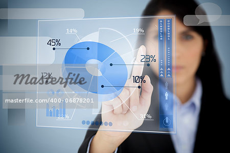 Serious businesswoman using blue pie chart interface  by touching it