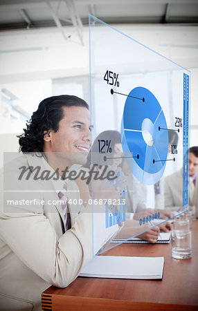 Smiling businessman looking at blue pie chart interface in a meeting