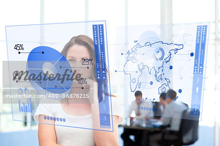 Smiling businesswoman looking at blue pie chart interface  with colleagues behind