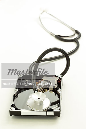 Disk drive with stethoscope resting on it on white background