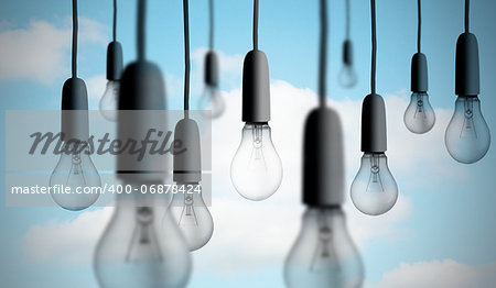 Group of light bulbs hanging against sky background