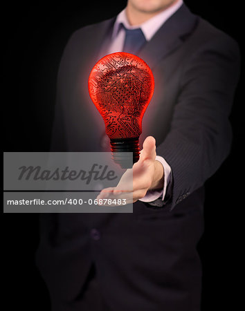 Businessman holding red light bulb against black background
