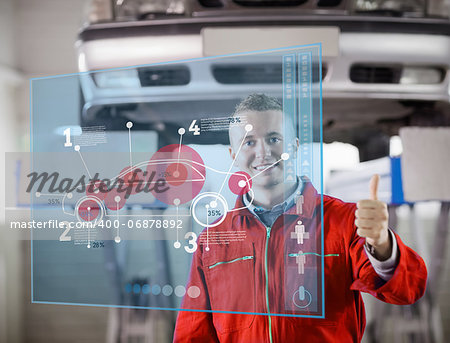 Portrait of smiling mechanic showing thumbs up with futurist interface with car diagram