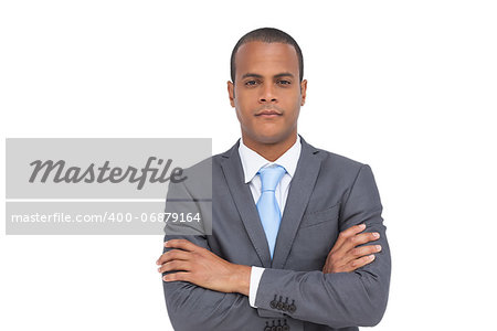 Charismatic businessman with arms crossed on white background