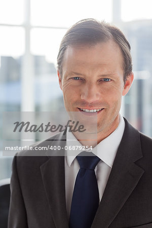 Confident businessman smiling and standing in his office