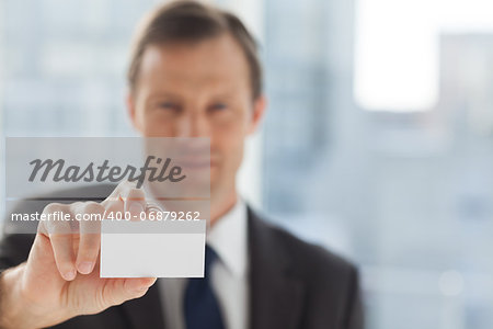 Businessman showing business card in his office