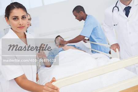 Nurse pushing bed of patient in emergency in hospital ward