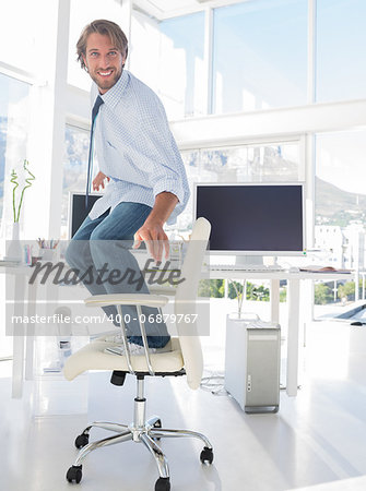 Man surfing his swivel chair in bright modern office