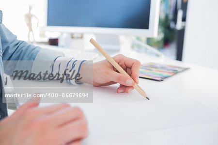 Female hands drawing on paper on her desk