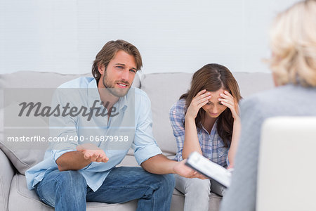 Couple arguing and crying on the couch during therapy session