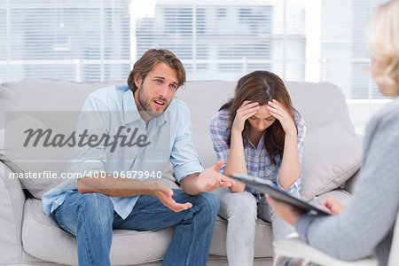 Man speaking to the therapist while her wife cries next to him