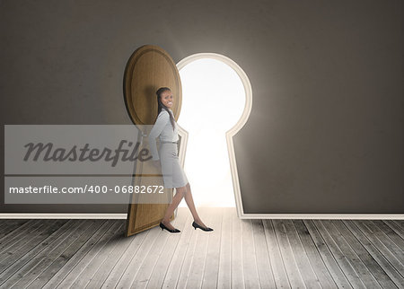 Businesswoman leaning against keyhole shaped doorway in dark grey room