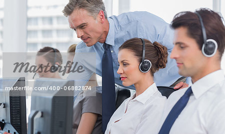 Manager helping call centre agent on a computer