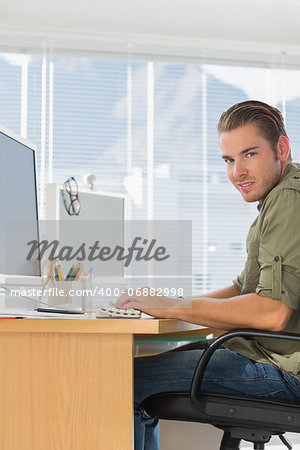 Cheerful creative business employee working on computer in a modern office