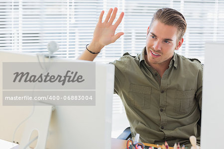 Creative business employee waving during a videocall