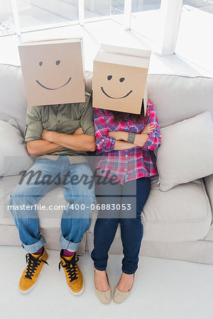 Silly employees wearing boxes on their heads with smiley faces on a couch