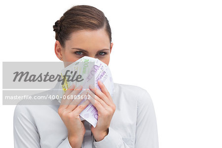 Businesswoman hiding behind money in her hands on white background