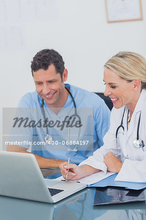 Two doctors working together on a laptop in a medical office