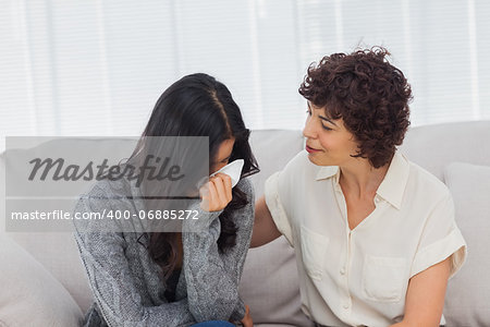 Patient crying next to her therapist while she is comforting her