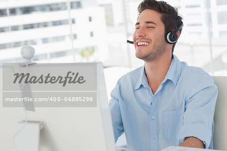 Happy designer laughing during an online communication in his office