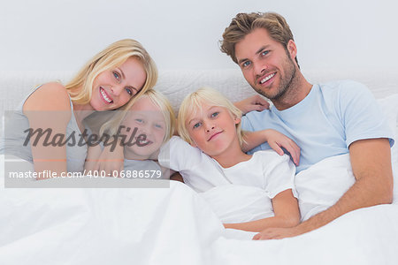 Portrait of a family sitting in bed