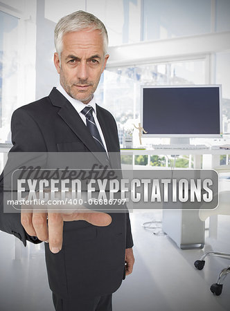 Businessman touching the term exceed expectations in his office