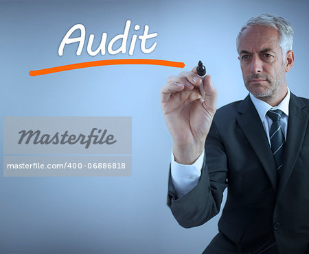Businessman writing the word audit with a marker