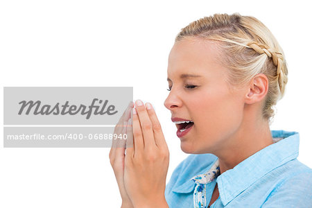 Sick blonde woman sneezing with hands in front of her face on white background