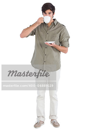 Young man drinking cup of coffee and looking at the camera