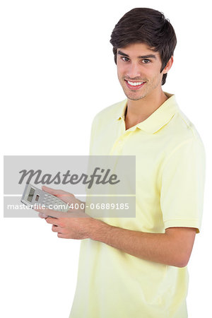 Smiling man using calculator on a white background