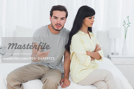 Woman sulking and her boyfriend doesnt know what to do in bedroom