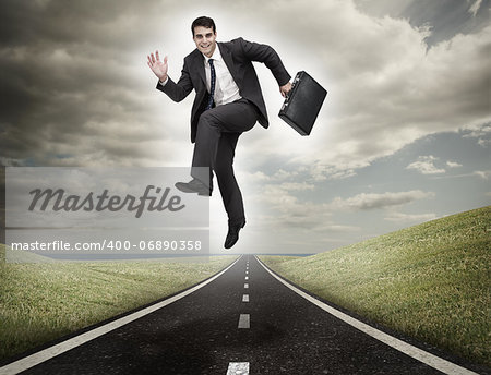 Businessman jumping on a road leading out to the horizon