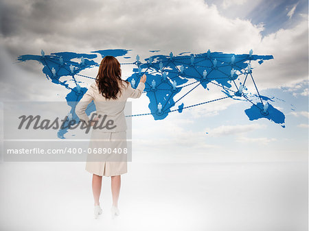 Businesswoman touching at a world map with blue sky on the background