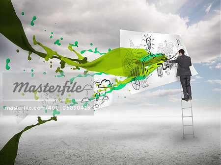 Businessman drawing on a paper next to green paint splash with blue sky on the background