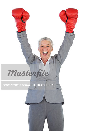 Happy businesswoman wearing boxing gloves and raising her arms on white blackground