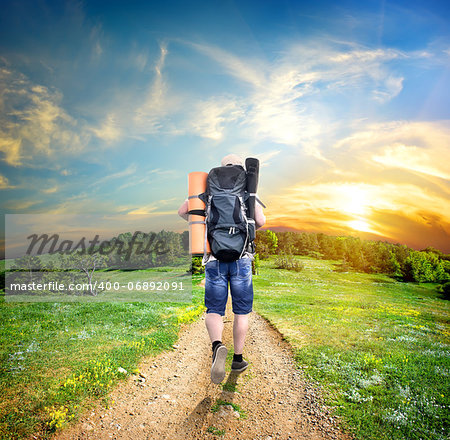 Man with a backpack walking on a country road