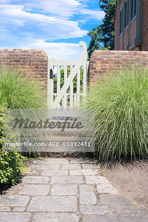 Natural Stone Path to Backyard Garden Gate with Brick Wall