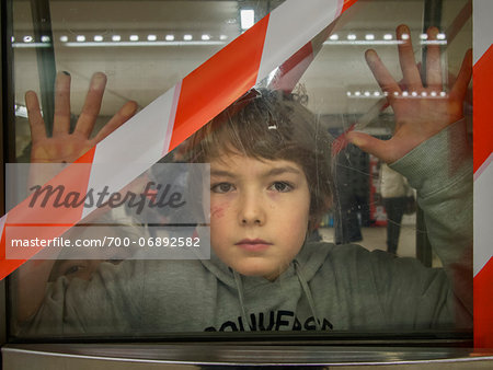 young boy behind blocked door in parisian subway, Paris, France