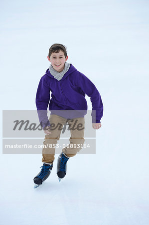 Boy ice-skating on a frozen lake