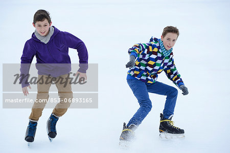 Two boys ice-skating on a frozen lake