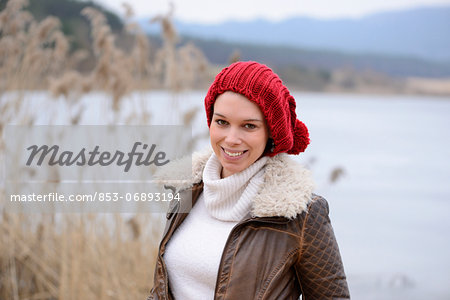 Smiling young woman at the shore of a lake, portrait