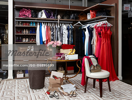 Women's closet / dressing room filled with clothing, handbags and shoes.