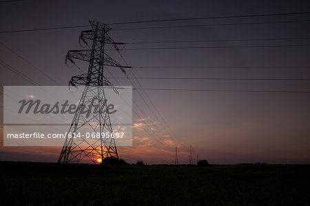 Silhouette of electrical towers at sunset